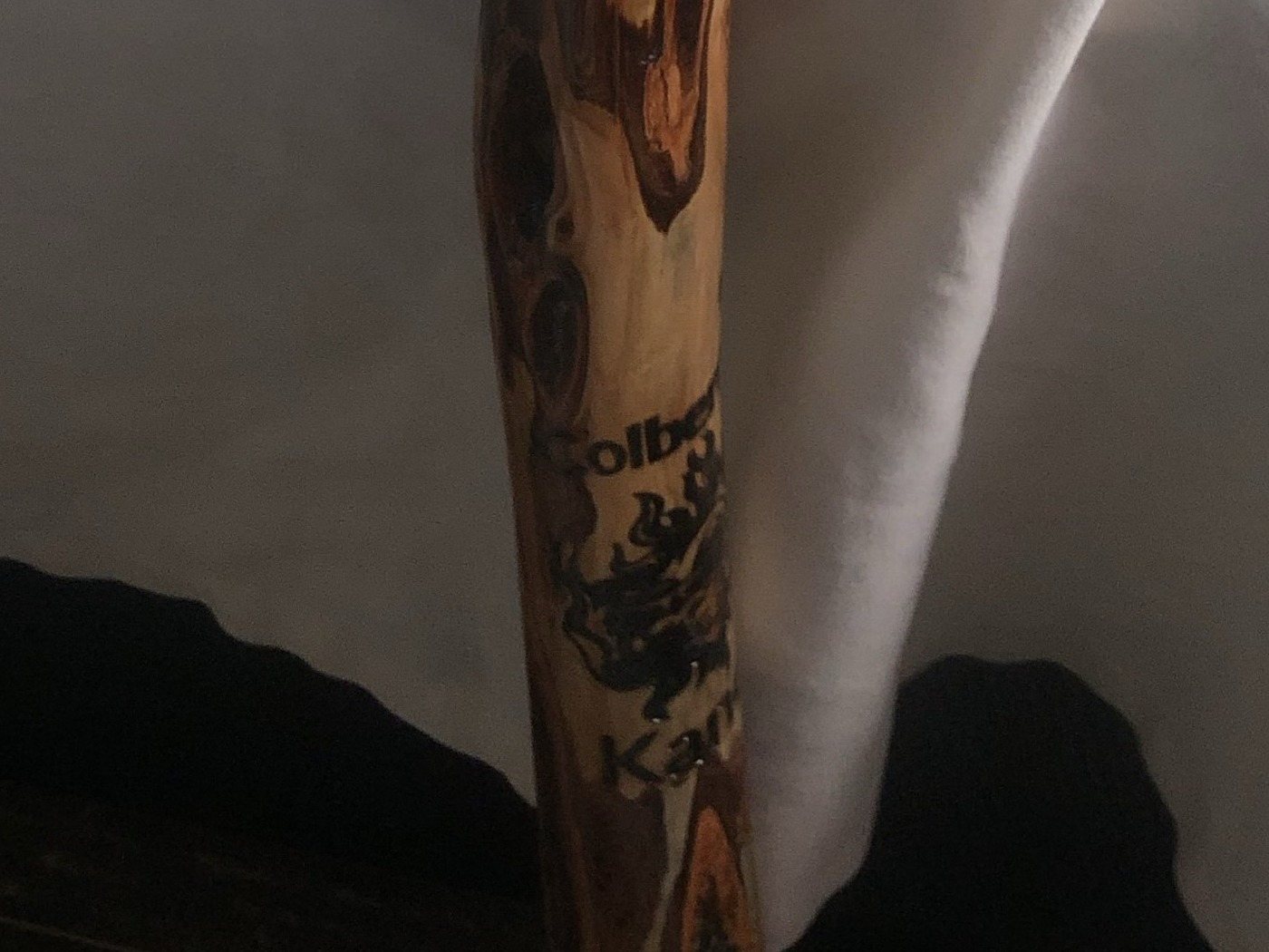 The maker's mark burned into the cane's shaft, the letters wrapping out of view.