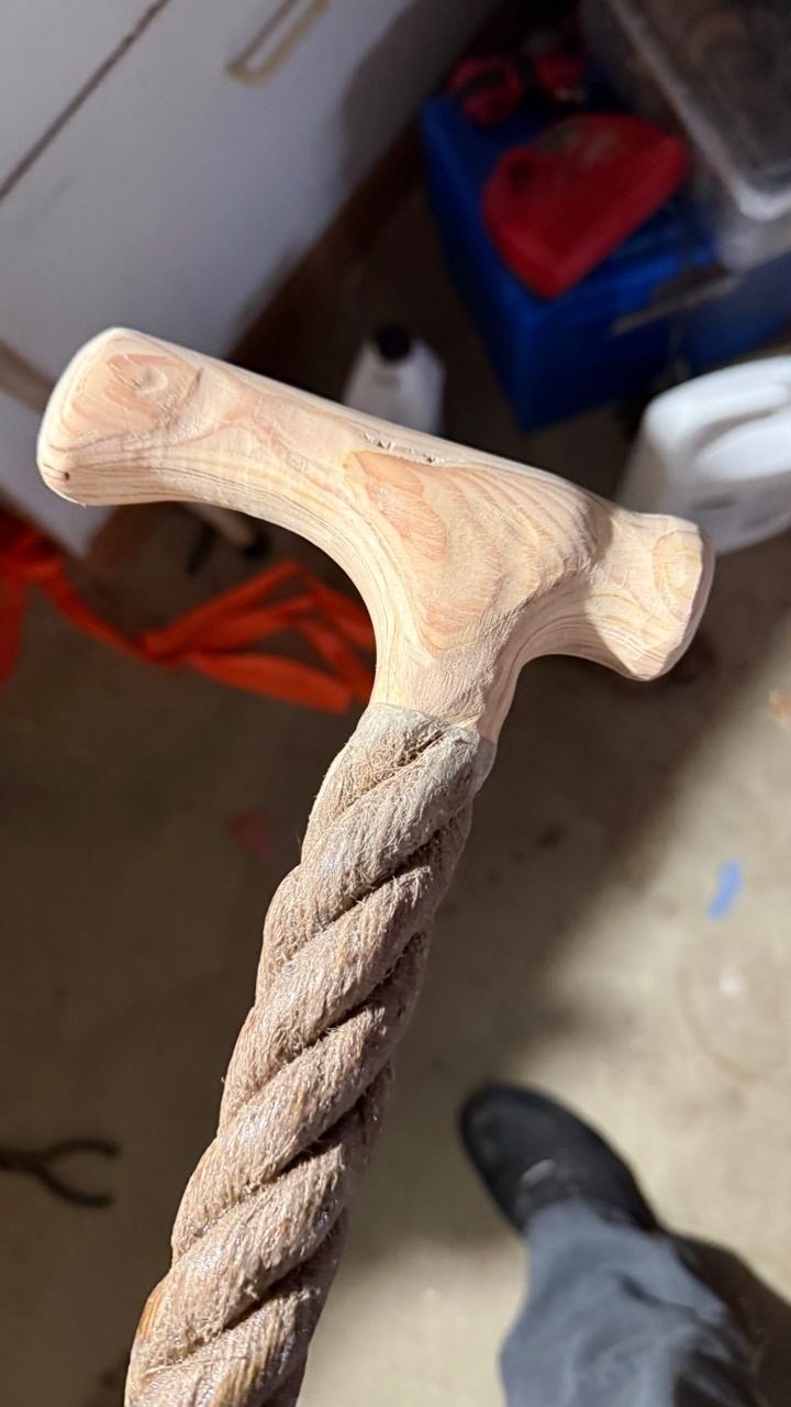 Work-in-progress pale wood T handle above a deeply carved spiral shaft in the workshop.