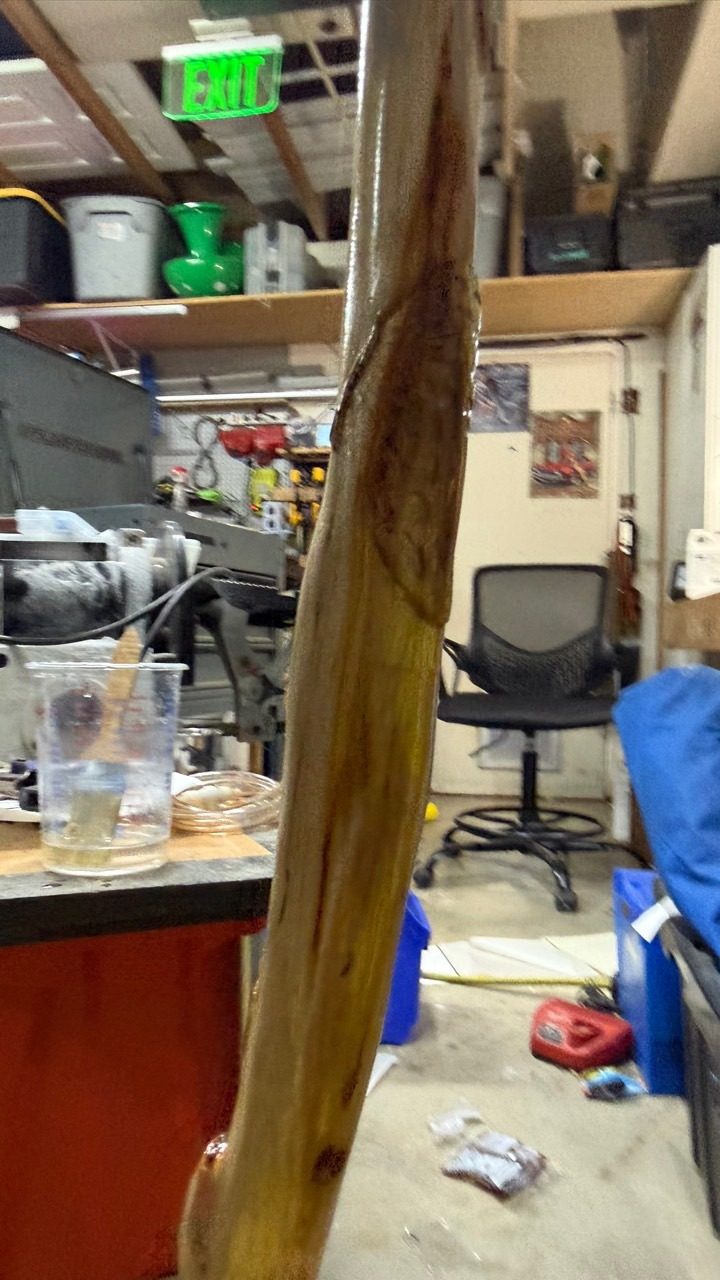 Close view of a newly polished natural wood shaft inside a working shop.
